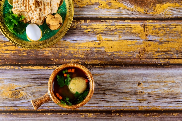 Traditionele Joodse matzo-balsoep en sederplaat op houten lijst