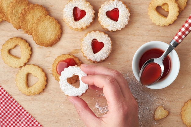 Traditionele kerst Linzer koekjes met aardbeienjam in houten lade op donker