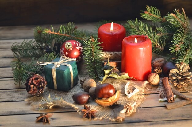 Traditionele kerstdecoratie op houten tafel met kaarsen en geschenkdoos