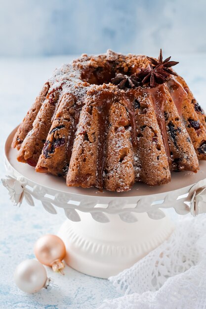 Traditionele kerstfruitcake, pudding op keramische witte standaard