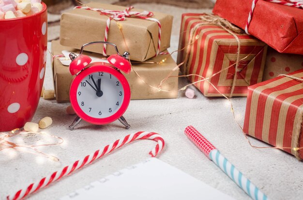 Traditionele kerstversiering cadeau voor boomtakken op pastelroze achtergrond plat lag