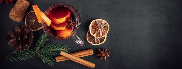 Traditionele kerstverwarmende glühwein. warme drank met kruiden in glazen beker op een donkere achtergrond.