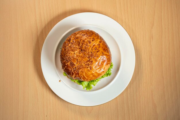 Foto traditionele klassieke burger geserveerd op een wit bord op een zwarte achtergrond vlees hamburger plat gelegd