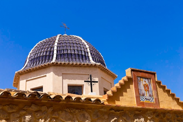 Traditionele koepel met blauwe keramische tegels en het beeld van de heilige in de kerk Relleu Alicante provincie