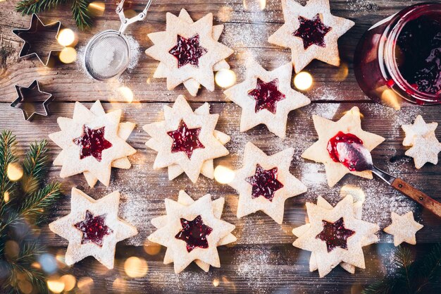 Traditionele Linzer-kerstkoekjes gevuld met frambozenjam op houten ondergrond