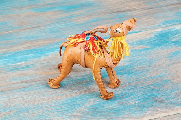 Traditionele Marokkaanse souvenir, lederen kameel op blauwe houten achtergrond.