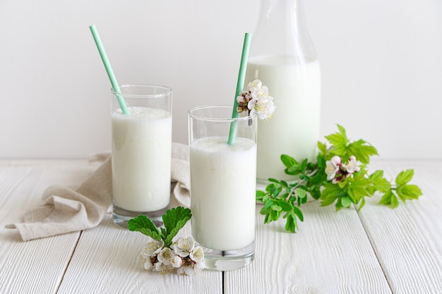 Traditionele melkdrank op een witte muur met groen en bloemen