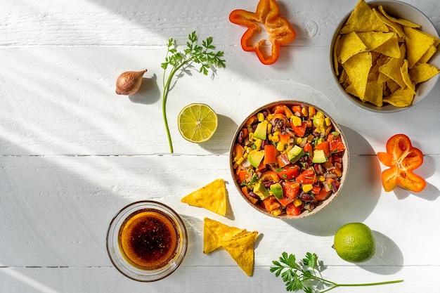 Traditionele Mexicaanse groentesalade cowboy kaviaar in kom met ingrediënten en nacho's