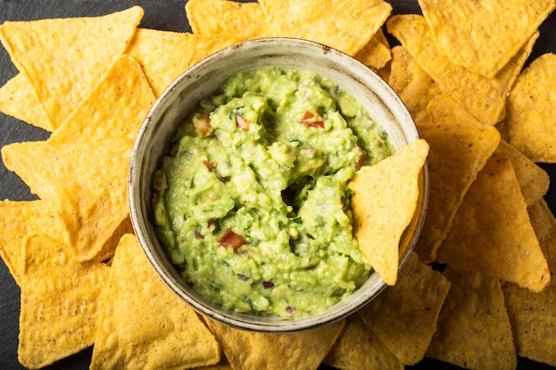 Traditionele Mexicaanse Guacamole saus gemaakt van avocado limoen rode ui tomaten koriander