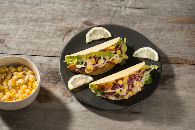 Traditionele Mexicaanse taco met kip en groenten op houten tafel. Latijns-Amerikaans eten.