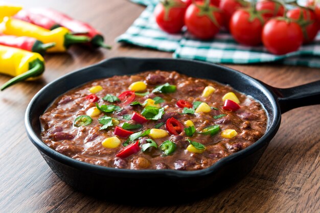 Traditionele Mexicaanse tex mex chili con carne in een koekenpan op houten tafel