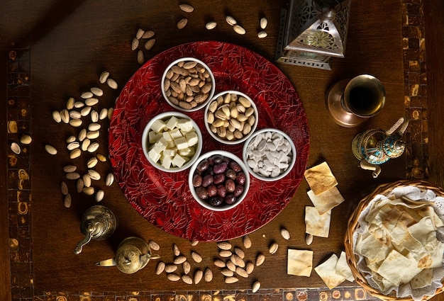 Traditionele Midden-Oosterse gerechten. Libanees eten. Arabische snacks, kaas, olijven, noten en zaden, lamp, bovenaanzicht