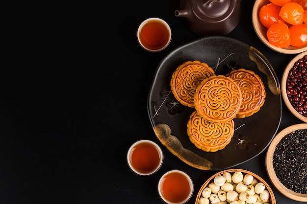 Traditionele mooncakes op lijst die met theekopje plaatst.