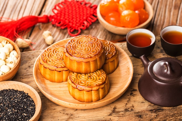 Traditionele mooncakes op lijst die met theekopje plaatst.