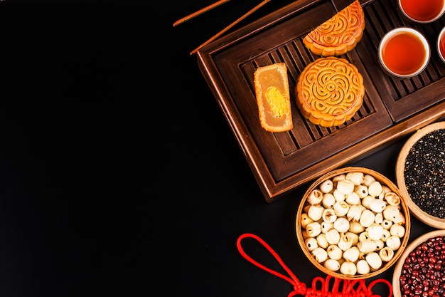 Traditionele mooncakes op lijst die met theekopje plaatst.