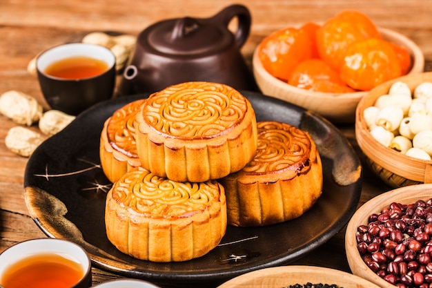 Traditionele mooncakes op lijst die met theekopje plaatst.