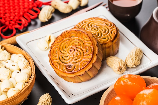 Traditionele mooncakes op lijst die met theekopje plaatst.