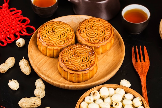 Traditionele mooncakes op lijst die met theekopje plaatst.