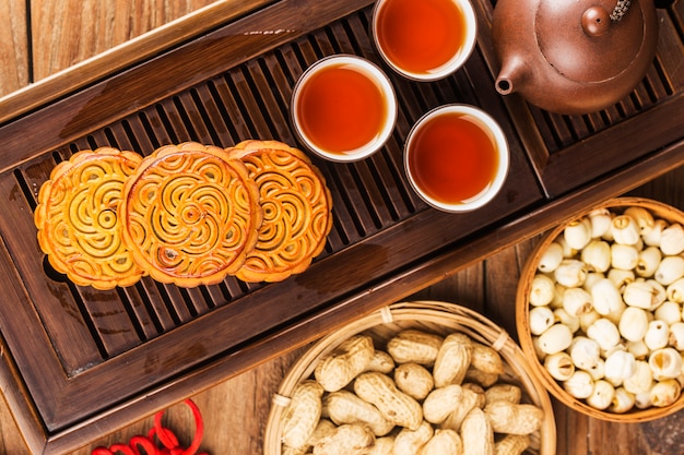 Traditionele mooncakes op lijst die met theekopje plaatst.