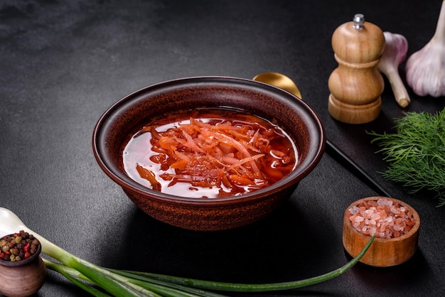 Traditionele Oekraïense borsjt met bieten, tomaten, knoflook, specerijen en kruiden, Oekraïens gerecht, traditioneel eten