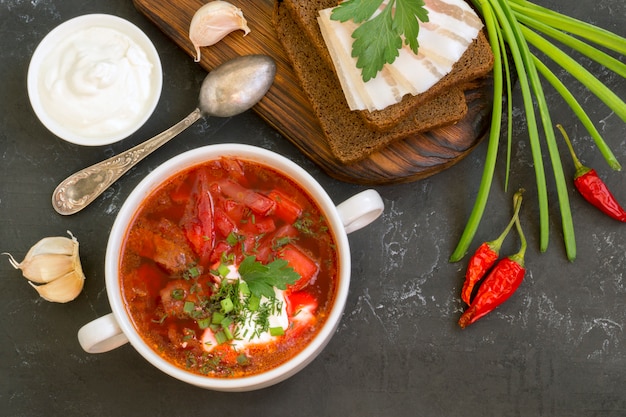 Traditionele Oekraïense Russische soep (borscht) van biet met greens en zure room.