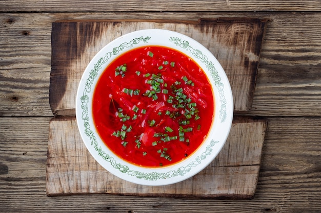 Traditionele Oekraïense vegetarische rode bietensoep - borsjt op houten achtergrond. Bovenaanzicht.