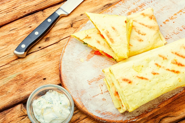 Traditionele oosterse shoarma met kip, kaas en champignons op keukenbord