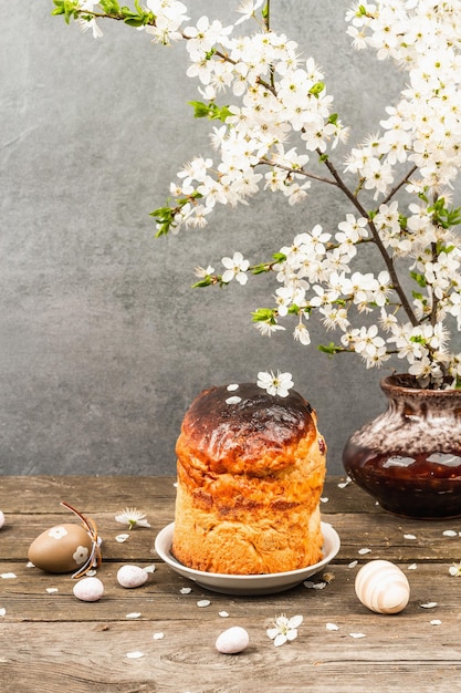 Traditionele paascake in een rustieke stijl Vintage bakpot bloeiende kersenpruimtakken Houten achtergrond