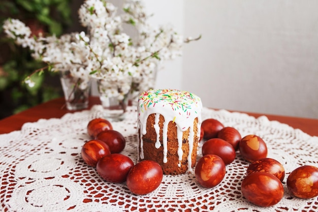 Traditionele paascake met glazuur en met de hand beschilderde eieren Zelfgemaakte muffins met poedersuiker