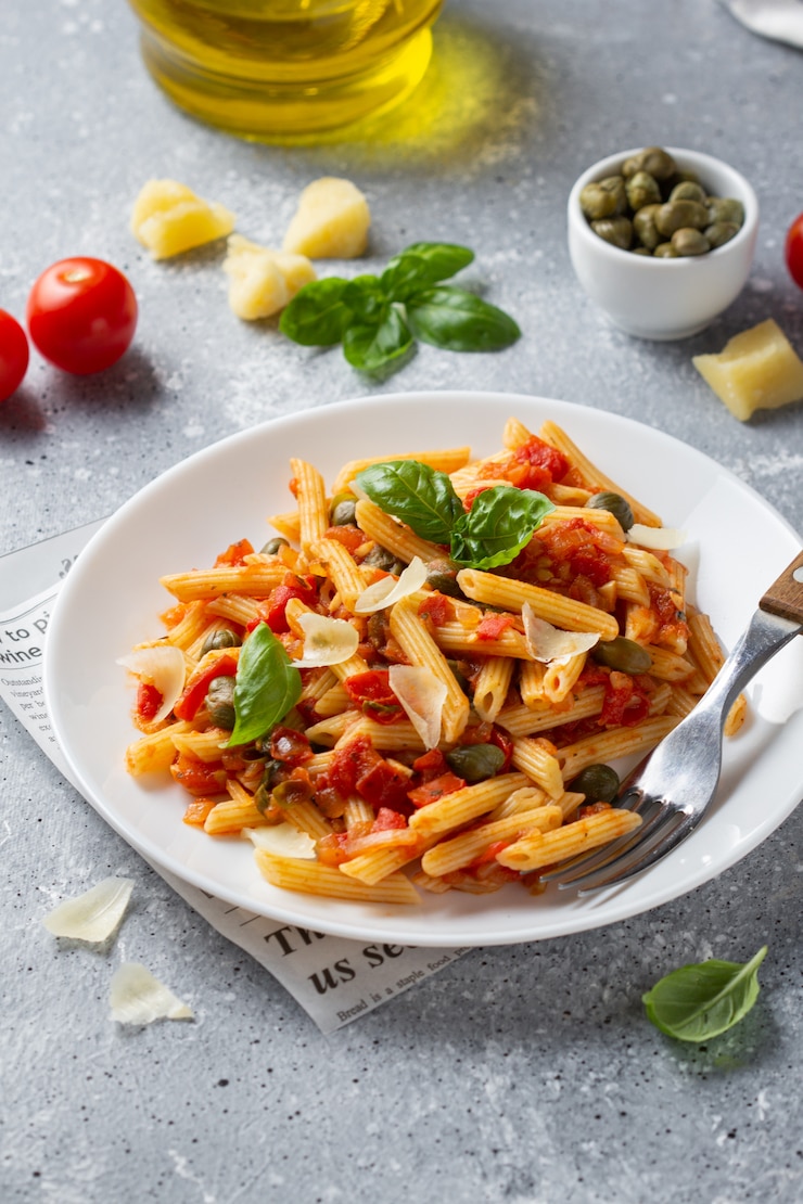 Foto traditionele pasta putanesca met tomatensaus (kappertjes, uien, knoflook, ansjovis)