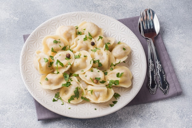 Traditionele pelmeni, ravioli, bollen gevuld met vlees op plaat, Russische keuken