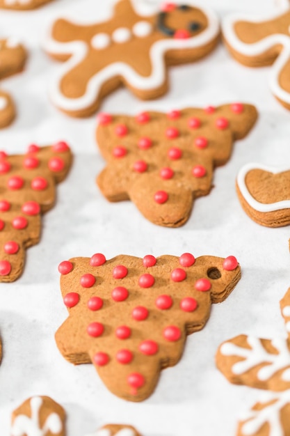 Foto traditionele peperkoekkoekjes versieren met royal icing voor kerstmis.