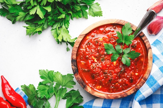 Traditionele pittige arrabiata-saus met hete rode pepers, knoflook en kruiden op witte keukentafel achtergrond bovenaanzicht Italiaanse keuken