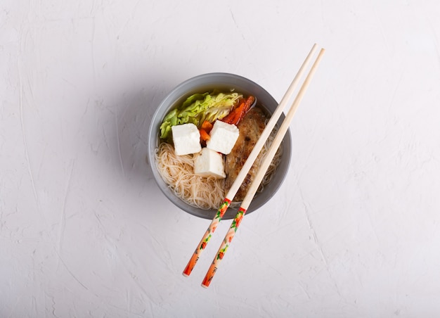 Traditionele pittige Aziatische soep met tofu kaas en noedels. witte achtergrond