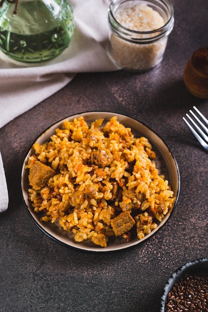 Traditionele pittige pilaf met rijst en vlees op een bord op de tafel verticaal