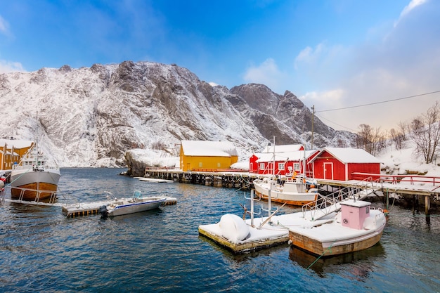 Traditionele rode en gele houten huizen rorbuer in het kleine vissersdorpje Nusfjord Lofoten eilanden Noorwegen Europa Noewegian fjord met visboten