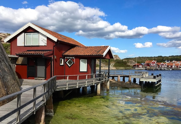 Traditionele rode hut op een ponton voor de zee onder blushemel in fjallbacka, zweden