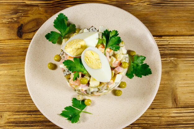 Traditionele Russische feestelijke salade Olivier op houten tafel Top view