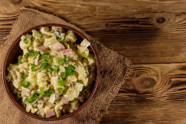 Traditionele Russische feestelijke salade Olivier op houten tafel