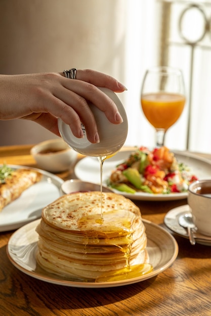 Traditionele Russische gebakjespannenkoekjes voor Maslenitsa-pannenkoeken met zalmpannenkoekjes met honingpannenkoekjes als ontbijt