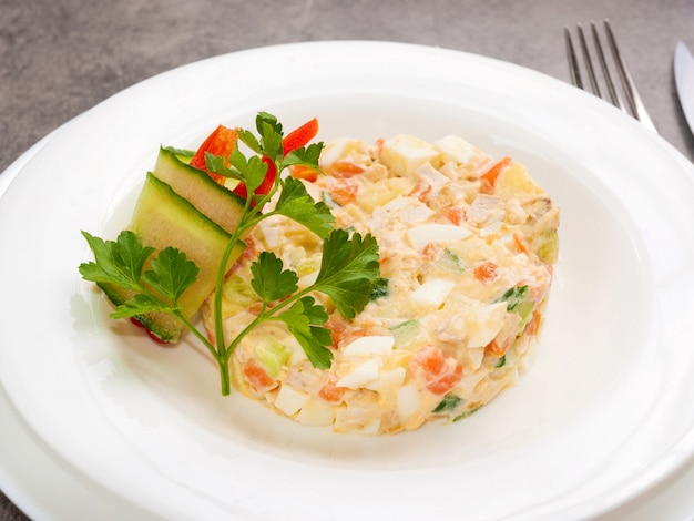 Traditionele Russische salade met kip op een witte plaat