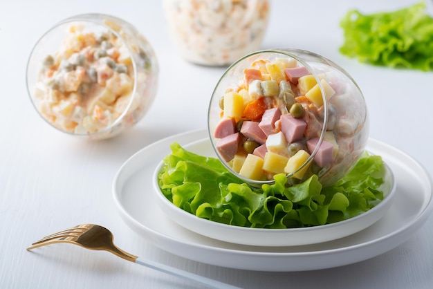 Traditionele Russische salade Olivier met groenten ham en mayonaise