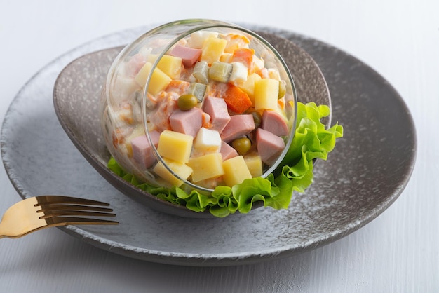 Traditionele Russische salade Olivier met groenten ham en mayonaise