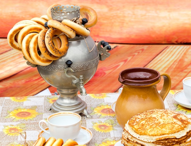 Foto traditionele russische samowar met smakelijke bagels en keramisch tafelgerei