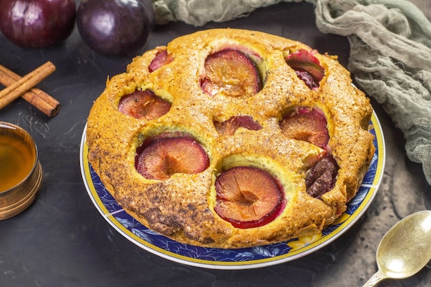 Traditionele rustieke pruimencake op een donkere achtergrond.