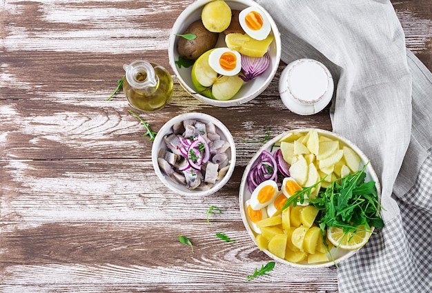 Traditionele salade van gezouten haringfilet, eieren, verse appels, rode ui en aardappelen.