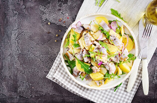 Traditionele salade van gezouten haringfilet, verse appels, rode ui en aardappelen.