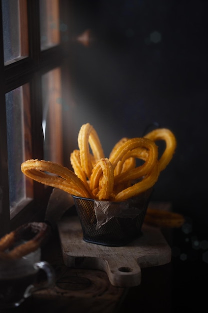 Traditionele Spaanse churros bij het raam. Donkere en humeurige foto, rustieke stijl