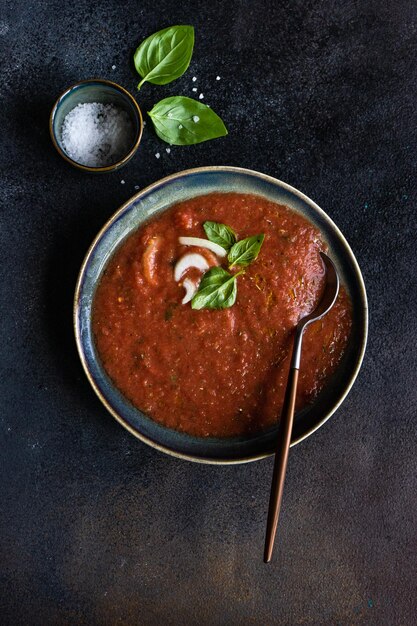 Traditionele Spaanse tomatensoep gazpacho in een keramische schaal met verse basilicumbladeren
