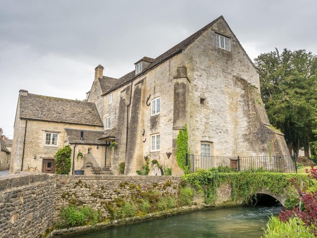 Traditionele stenen huisjes in het vredige dorp Bibury in Cotswold, Engeland onder bewolkte hemel